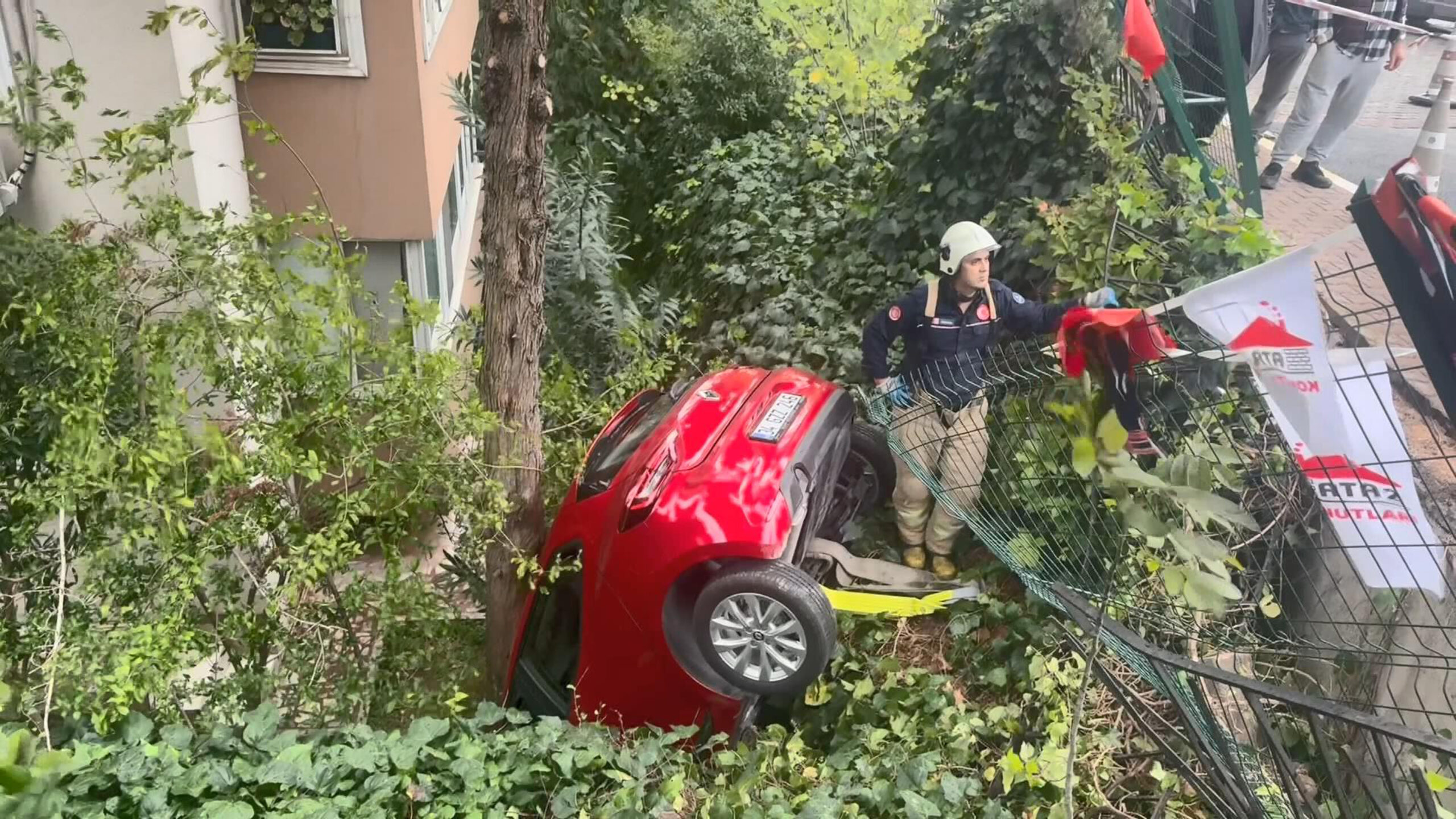 Otomobil binanın bahçesine düştü